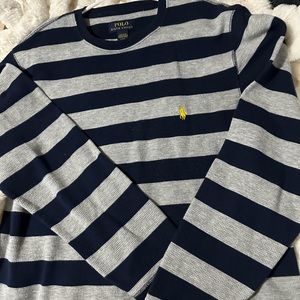 Navy blue and gray striped shirt with yellow polo sign.
